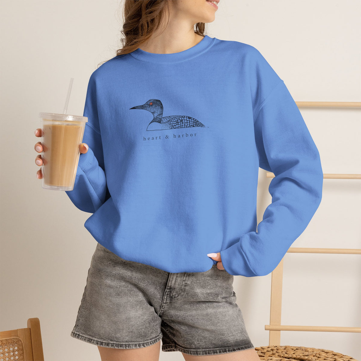 Unisex blue Gildan 18000 crewneck sweatshirt featuring original hand-drawn Heart & Harbor common loon artwork