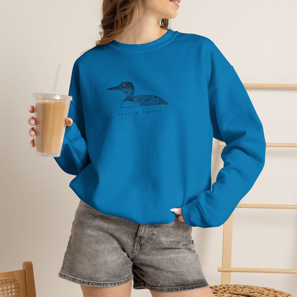 Unisex bright blue Gildan 18000 crewneck sweatshirt featuring original hand-drawn Heart & Harbor common loon artwork