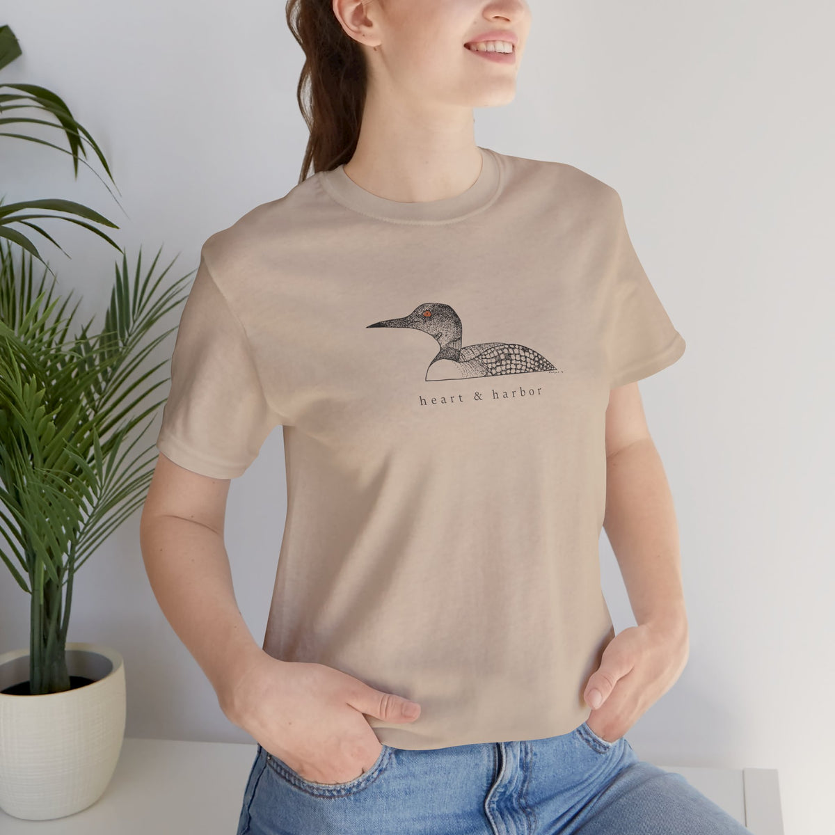 Unisex tan Bella+Canvas 3001 tee featuring original hand-drawn Heart & Harbor common loon artwork
